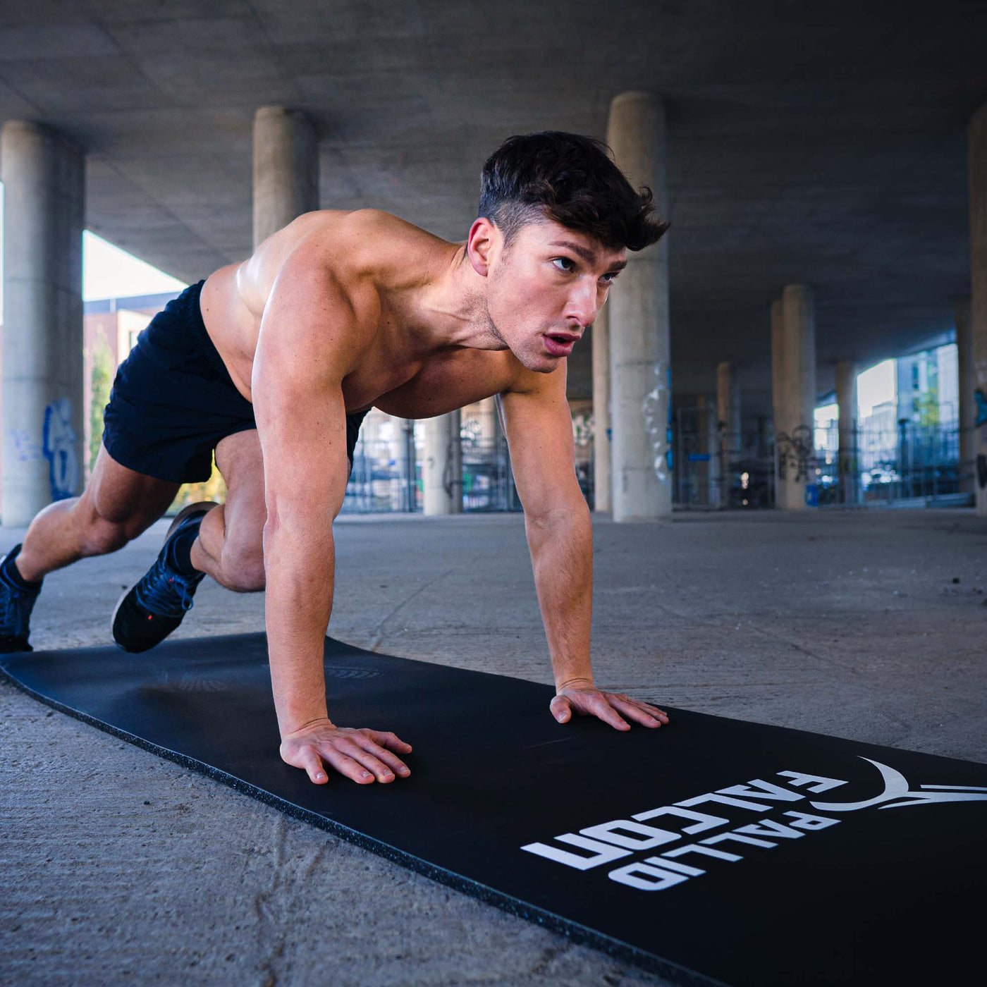 sportlicher mann trainiert outdoor auf pallid falcon gymnastikmatte